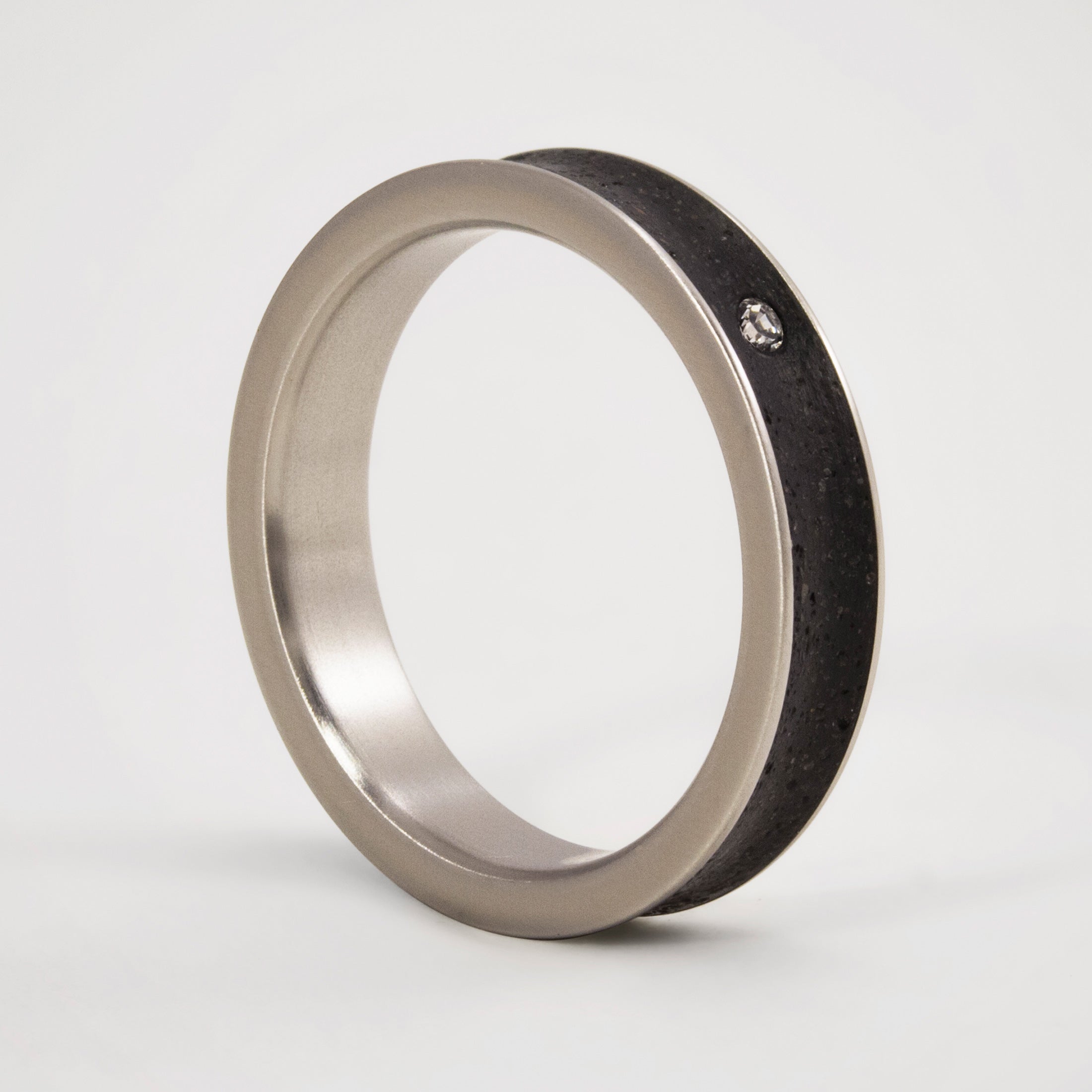 Anillo cóncavo concreto negro y titanio con cristal